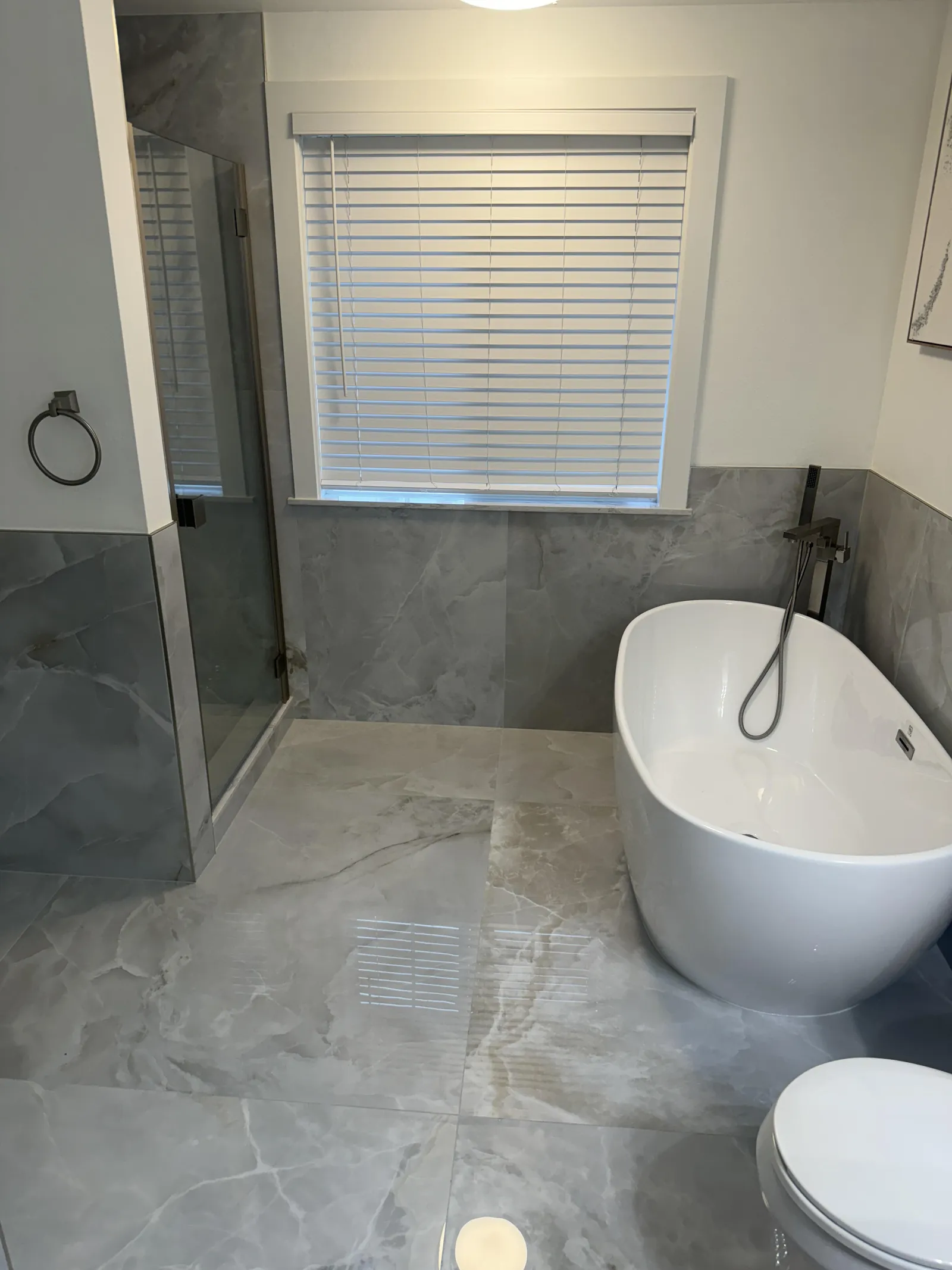 Remodeled bathroom with custom tile shower by Big Build Construction